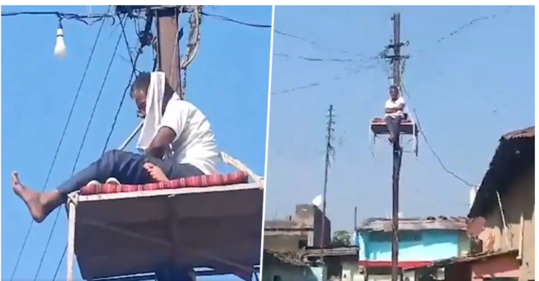 बिजली का खंबा हटाने के लिए पोल पर खाट लटका कर प्रदर्शन कर रहा किसान